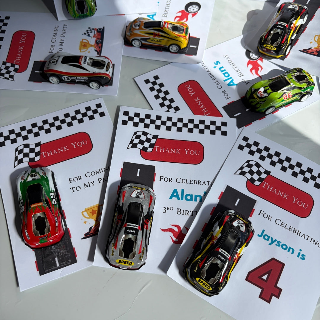 A set of custom die-cast toy race cars displayed on top of printed race-themed thank-you cards. The cards feature checkered flags, red 'THANK YOU' banners, and birthday text with names like 'Alan' and 'Jayson'.