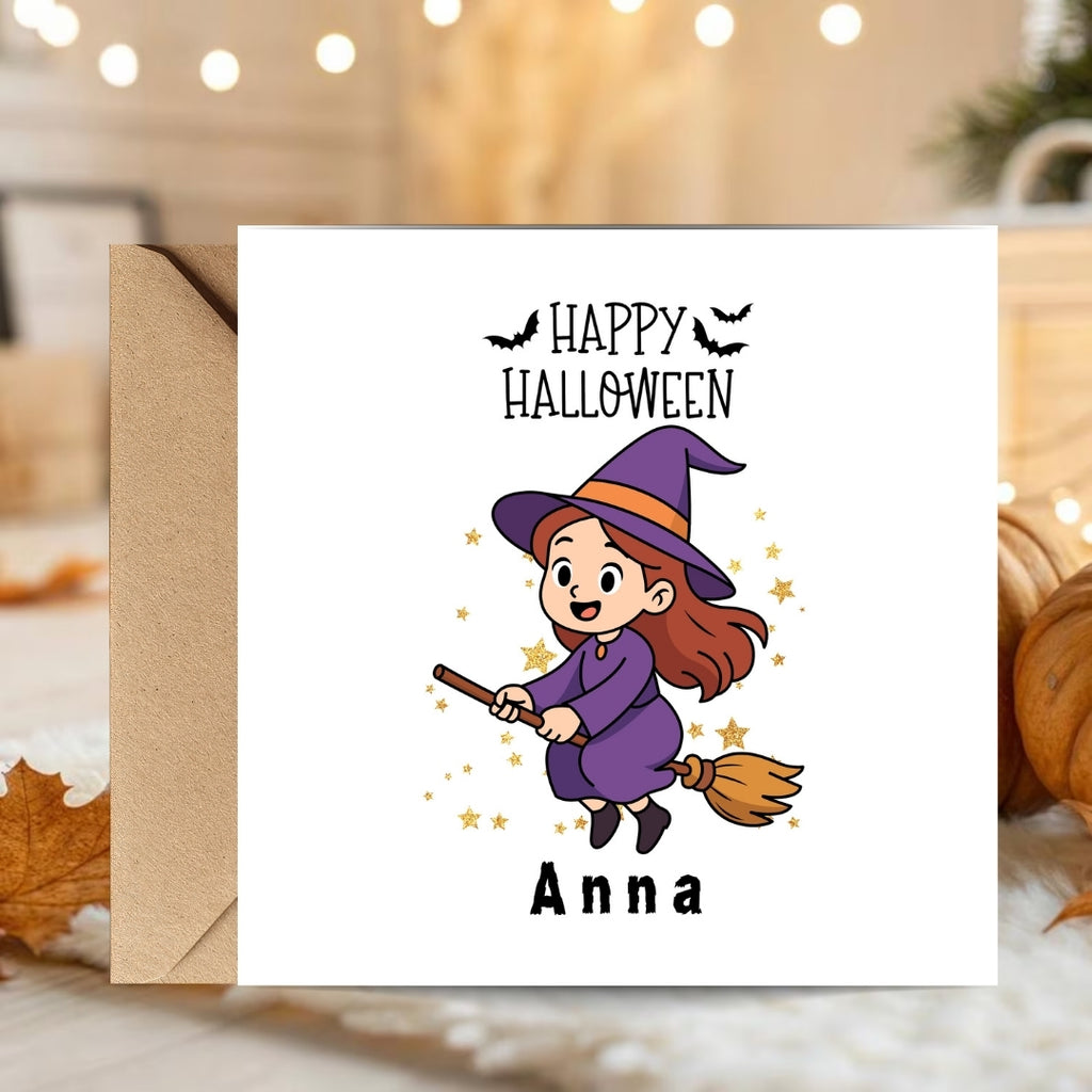 A personalized Halloween greeting card with a white front, featuring a cartoon witch riding a broomstick with the text 'Happy Halloween' and the name 'Anna', shown with a brown envelope against a cozy autumn-themed background.