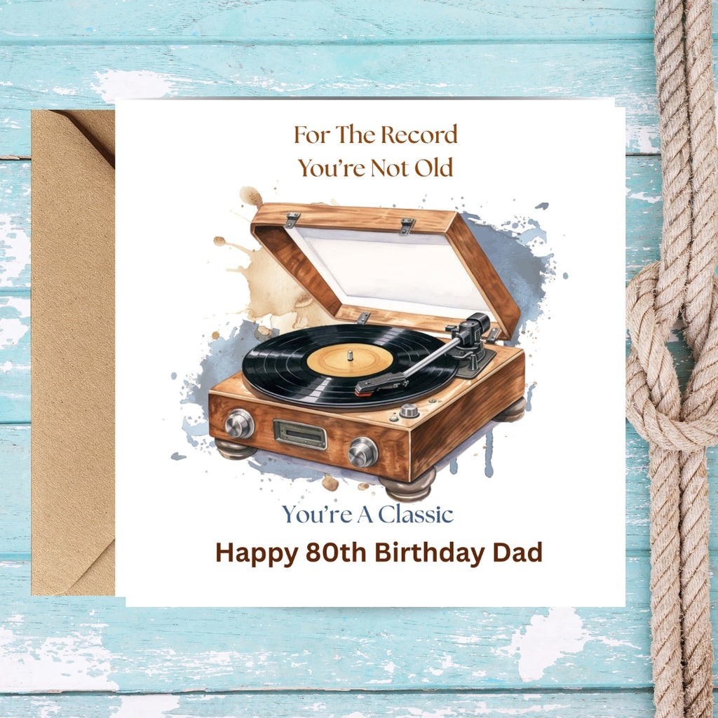 A square birthday card for an 80th birthday, featuring a watercolor illustration of a wooden record player. The card reads 'For The Record You're Not Old' and 'You're A Classic Happy 80th Birthday Dad'.