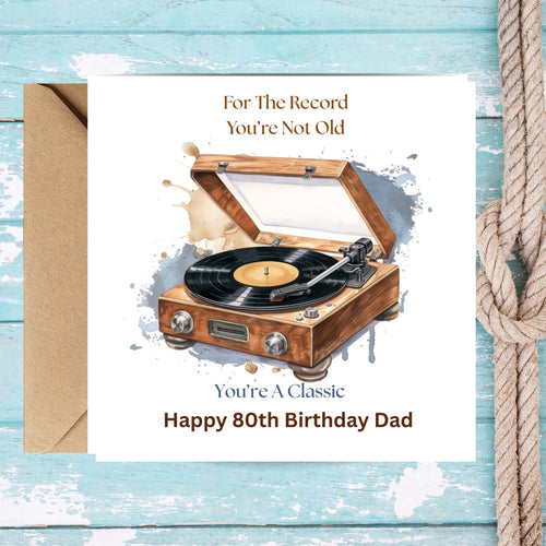 A square birthday card for an 80th birthday, featuring a watercolor illustration of a wooden record player. The card reads 'For The Record You're Not Old' and 'You're A Classic Happy 80th Birthday Dad'.