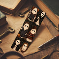 A rectangular notebook or journal with a Halloween-themed ghost illustration, displayed on a styled desk with old books, keys, and a pen.