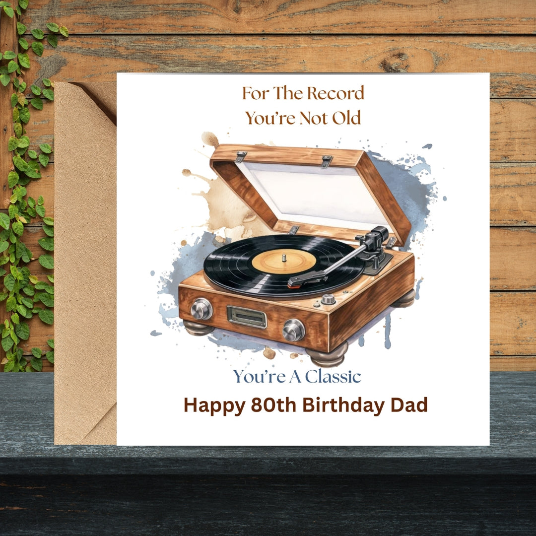 A personalized birthday card for a 80th birthday dad, featuring a watercolor illustration of a wooden turntable with a vinyl record. The card reads 'For The Record You're Not Old' and 'You're A Classic Happy 80th Birthday Dad'.